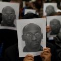 A crowd of protesters hold up pictures of Troy Davis's face to their own