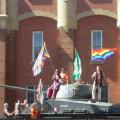 Gay Pride marchers wave rainbow flags atop Calgary's Mewata Armoury tank