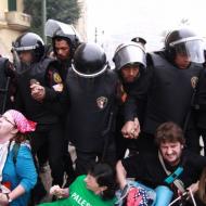 Gaza Freedom March protest occupies part of Tahrir Square in downtown Cairo,: seated protesters with a line of riot police.